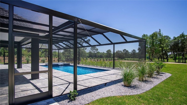 view of pool with a yard, glass enclosure, and a patio area