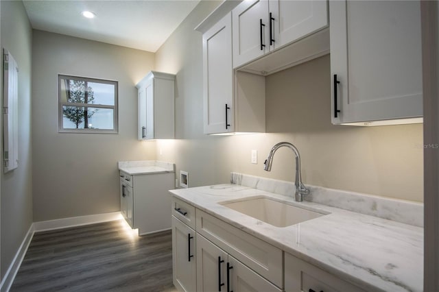 laundry area featuring hookup for a washing machine, sink, cabinets, and dark wood-type flooring