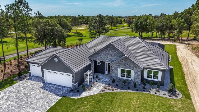 17694 SW 61st Lane Rd, Dunnellon, FL 34432 - view of front facade with stone siding, a garage, decorative driveway, stucco siding, and a front yard