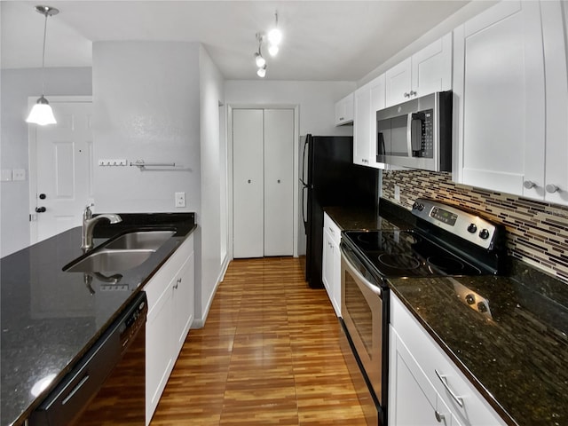 kitchen featuring black appliances, sink, dark stone countertops, decorative light fixtures, and white cabinetry