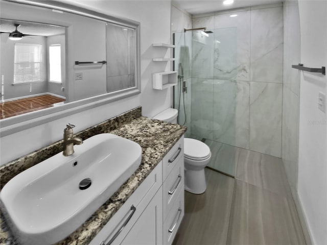 bathroom featuring vanity, ceiling fan, toilet, and walk in shower