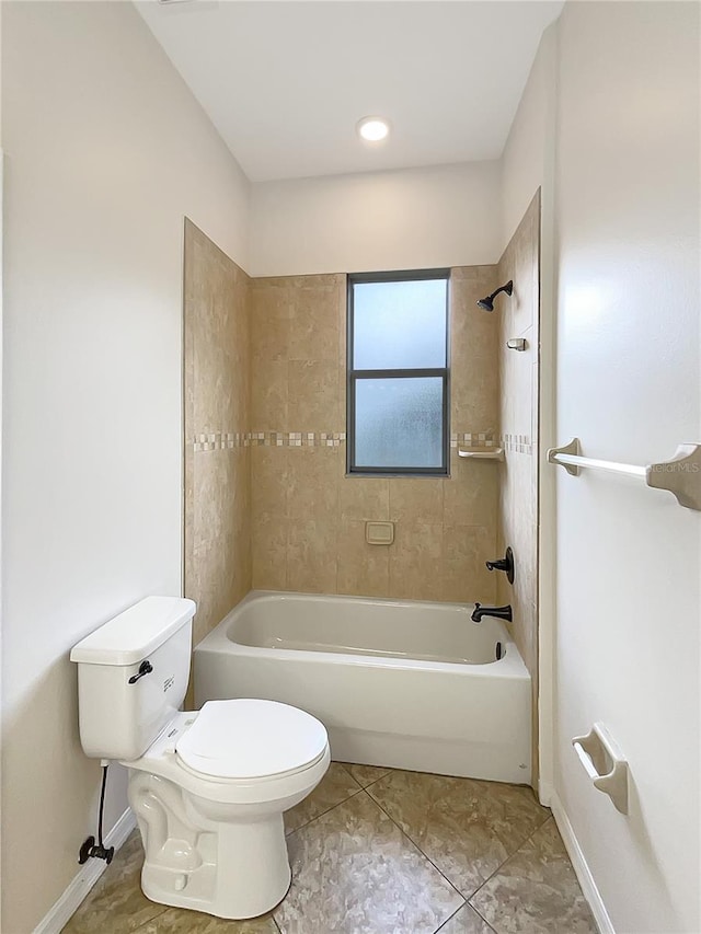 bathroom with tile patterned flooring, tiled shower / bath combo, and toilet