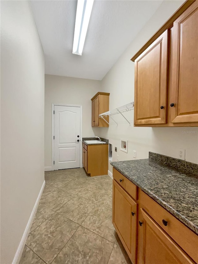 clothes washing area featuring washer hookup, cabinets, and light tile patterned floors