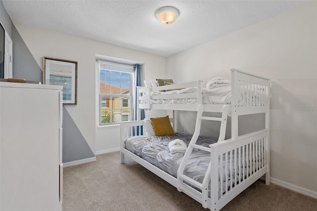 bedroom featuring carpet flooring, a textured ceiling, and baseboards