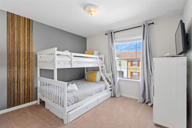 carpeted bedroom with a textured ceiling and baseboards