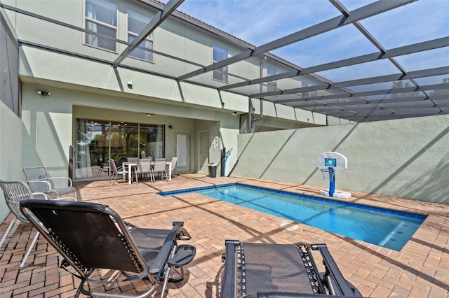 outdoor pool featuring glass enclosure, a patio area, and outdoor dining area