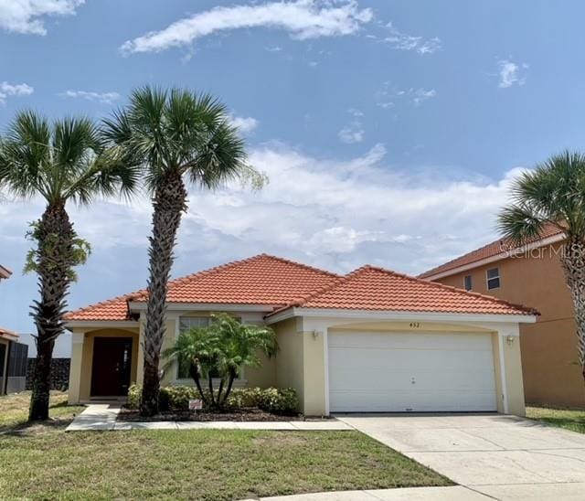 mediterranean / spanish home with a garage and a front lawn