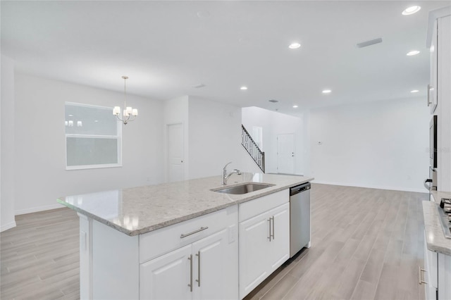 kitchen featuring dishwasher, sink, a kitchen island with sink, white cabinets, and light wood-type flooring