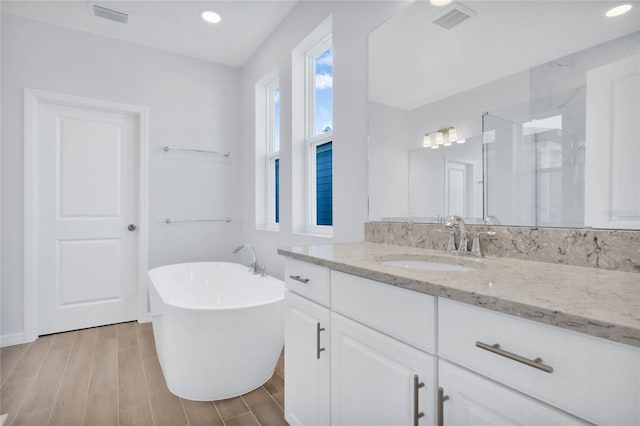 bathroom featuring hardwood / wood-style flooring, vanity, and independent shower and bath