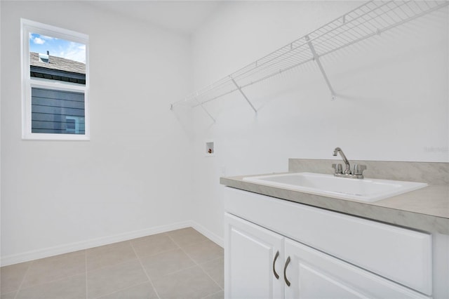 washroom with hookup for a washing machine, light tile patterned floors, cabinets, and sink