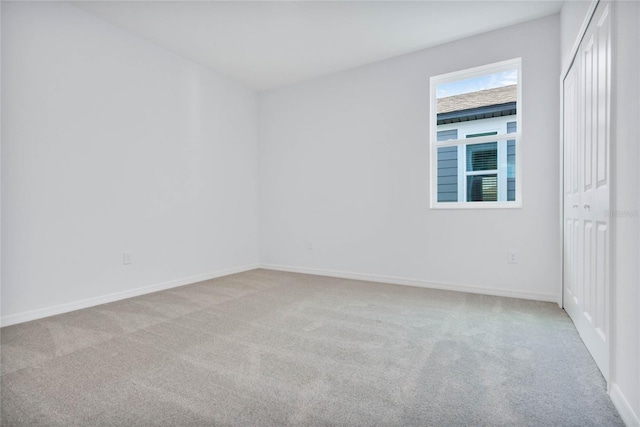 unfurnished room featuring light carpet