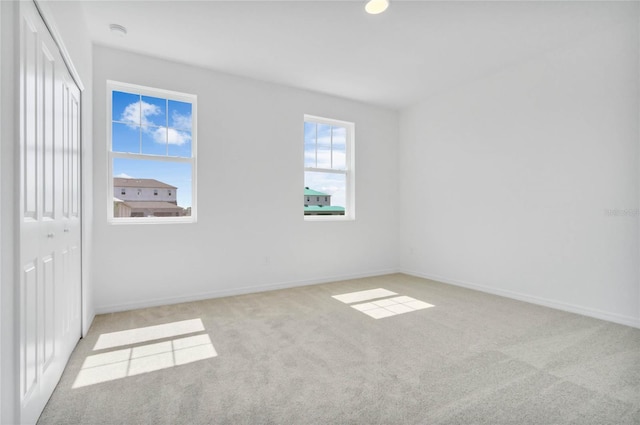 unfurnished room with light carpet