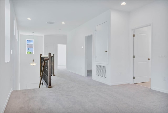 corridor featuring light colored carpet