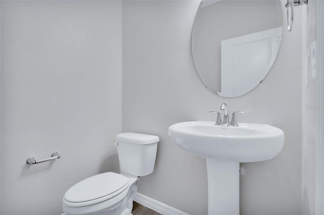 bathroom featuring hardwood / wood-style floors and toilet