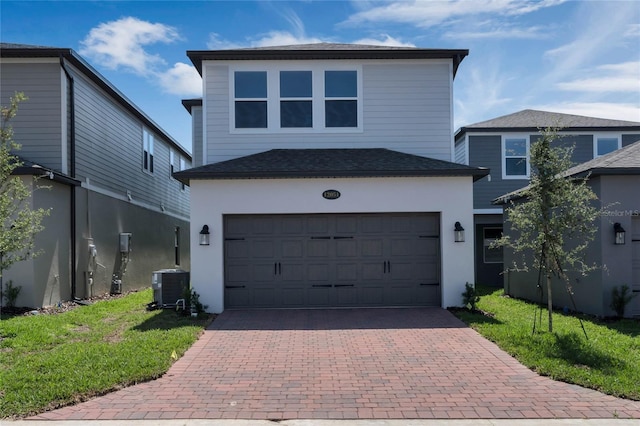 view of front property featuring a garage and central air condition unit