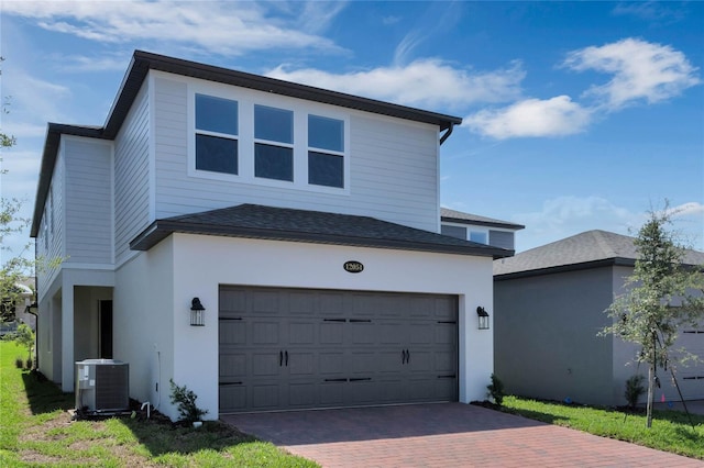 view of front of property featuring a garage and central AC