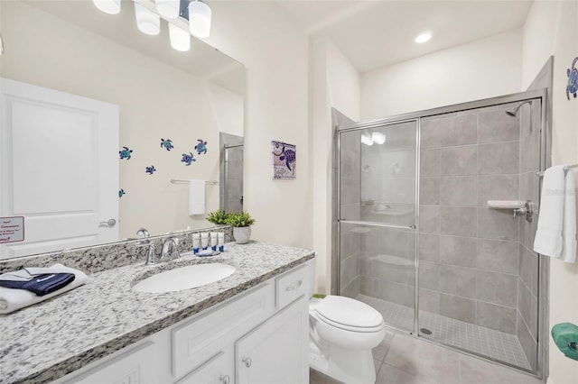 bathroom with tile patterned flooring, vanity, toilet, and walk in shower