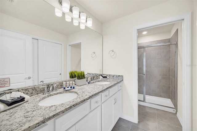 bathroom featuring tile patterned flooring, vanity, and a shower with shower door