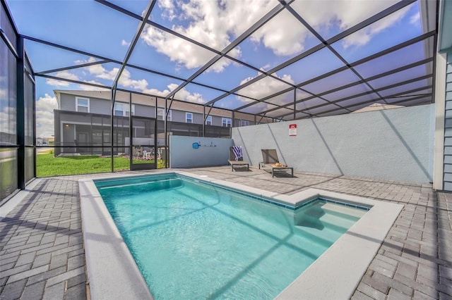 view of swimming pool featuring a lanai and a patio