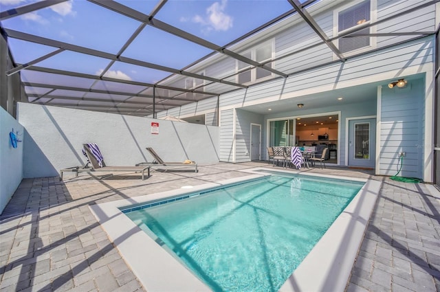 view of swimming pool with glass enclosure and a patio area