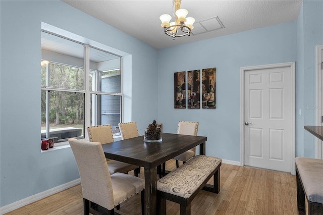 dining room featuring light hardwood / wood-style floors and a notable chandelier