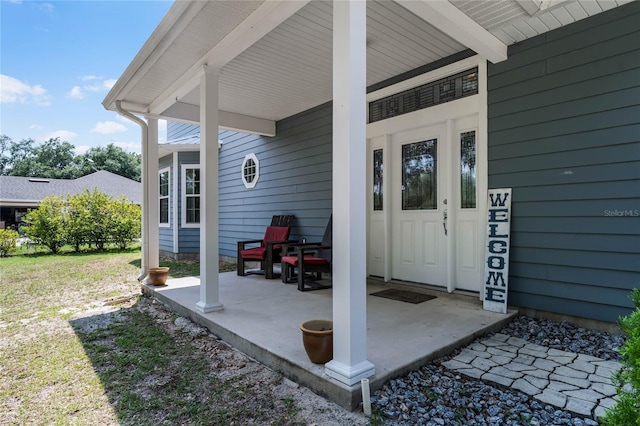 doorway to property with a porch and a lawn