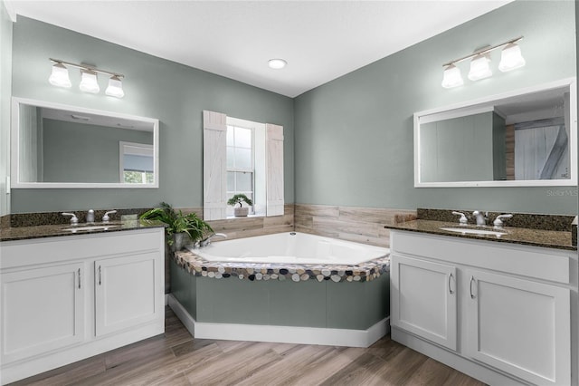 bathroom with hardwood / wood-style floors, vanity, and a tub