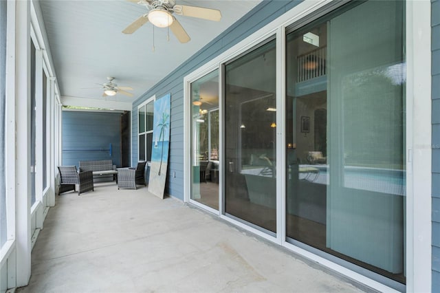 unfurnished sunroom with ceiling fan