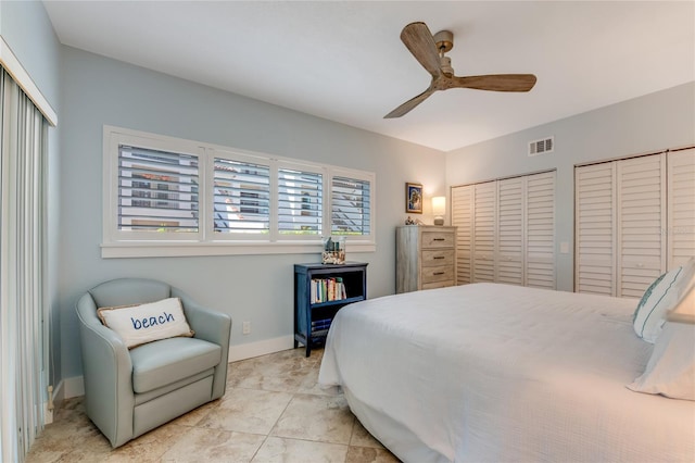 tiled bedroom featuring ceiling fan and multiple closets