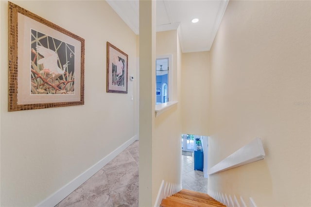 staircase with ornamental molding and tile patterned flooring