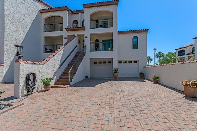 mediterranean / spanish home with a garage and a balcony