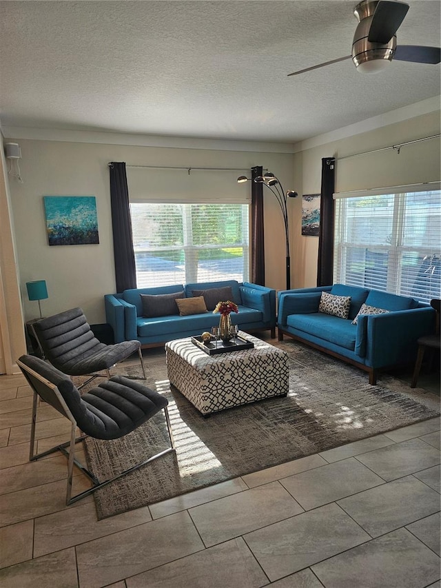 tiled living room featuring ceiling fan and a textured ceiling