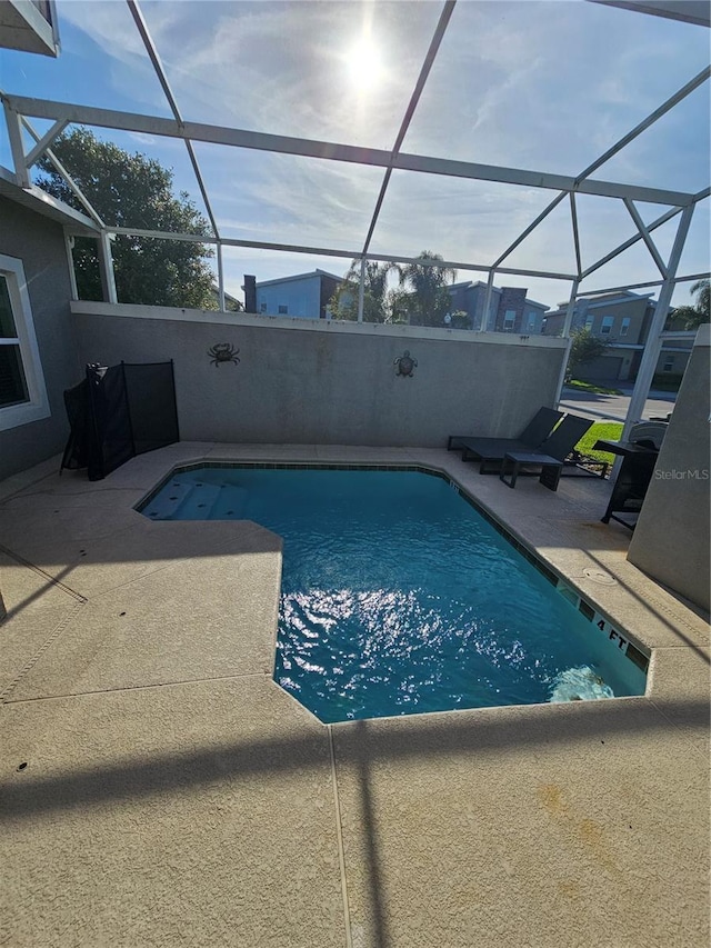 view of swimming pool featuring a patio area and a lanai