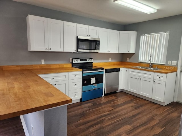 kitchen featuring appliances with stainless steel finishes, sink, white cabinets, wooden counters, and dark wood-type flooring