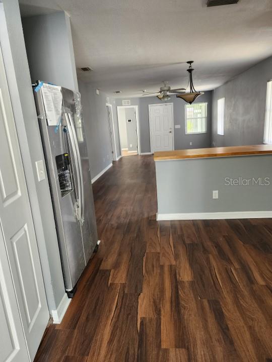 kitchen featuring ceiling fan, dark hardwood / wood-style flooring, and stainless steel fridge with ice dispenser