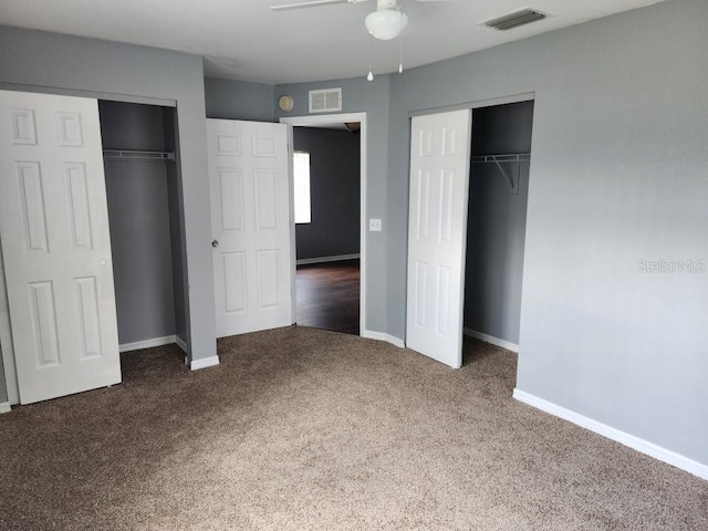 unfurnished bedroom with ceiling fan and dark carpet