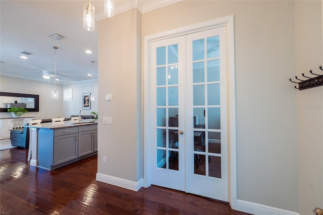 kitchen featuring sink, dark hardwood / wood-style flooring, hanging light fixtures, and french doors