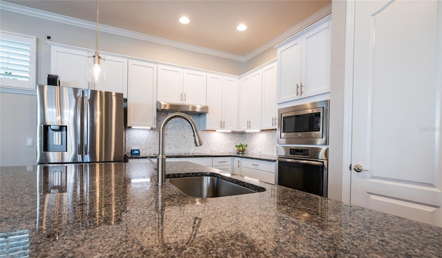 kitchen with sink, hanging light fixtures, dark stone countertops, white cabinets, and appliances with stainless steel finishes