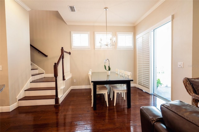 dining space with ornamental molding, dark wood-type flooring, and a notable chandelier