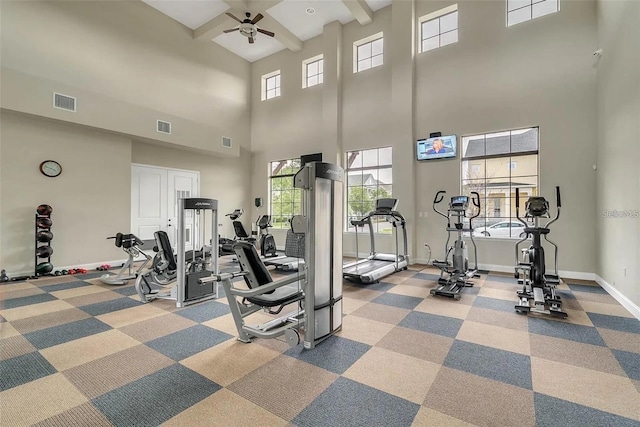 gym featuring light carpet, a high ceiling, and ceiling fan