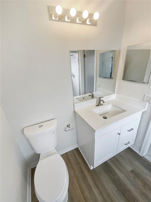 bathroom featuring hardwood / wood-style floors, vanity, and toilet