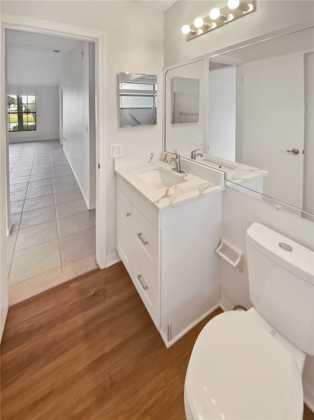 bathroom with vanity, toilet, and wood-type flooring