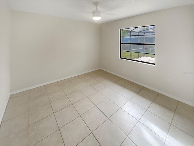 tiled spare room featuring ceiling fan