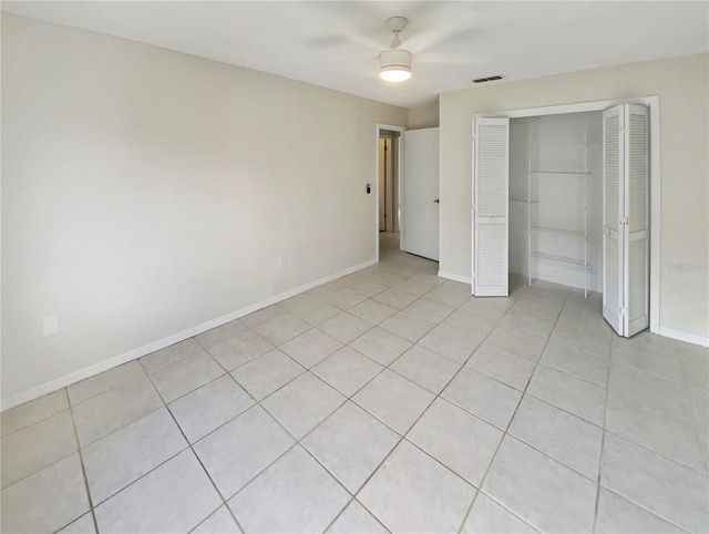 unfurnished bedroom with ceiling fan, light tile patterned floors, and a closet