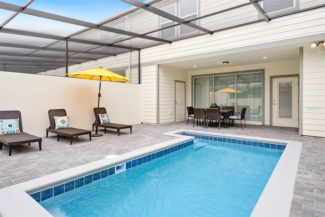 view of swimming pool featuring glass enclosure and a patio area