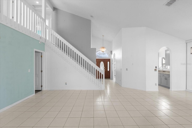 interior space with sink, light tile patterned floors, and high vaulted ceiling