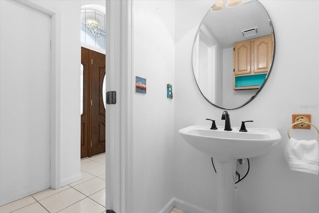 bathroom with an inviting chandelier and tile patterned floors