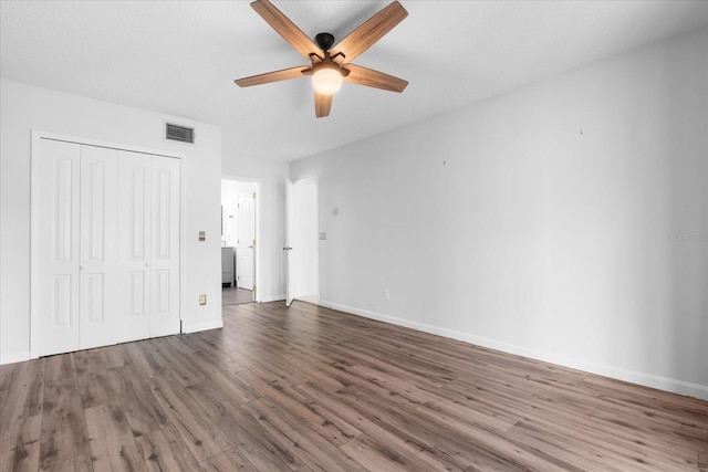 unfurnished bedroom featuring dark hardwood / wood-style flooring, a closet, and ceiling fan