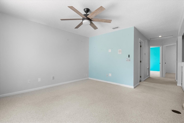 carpeted empty room with ceiling fan and a textured ceiling