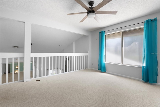 carpeted spare room with ceiling fan, lofted ceiling, and a textured ceiling